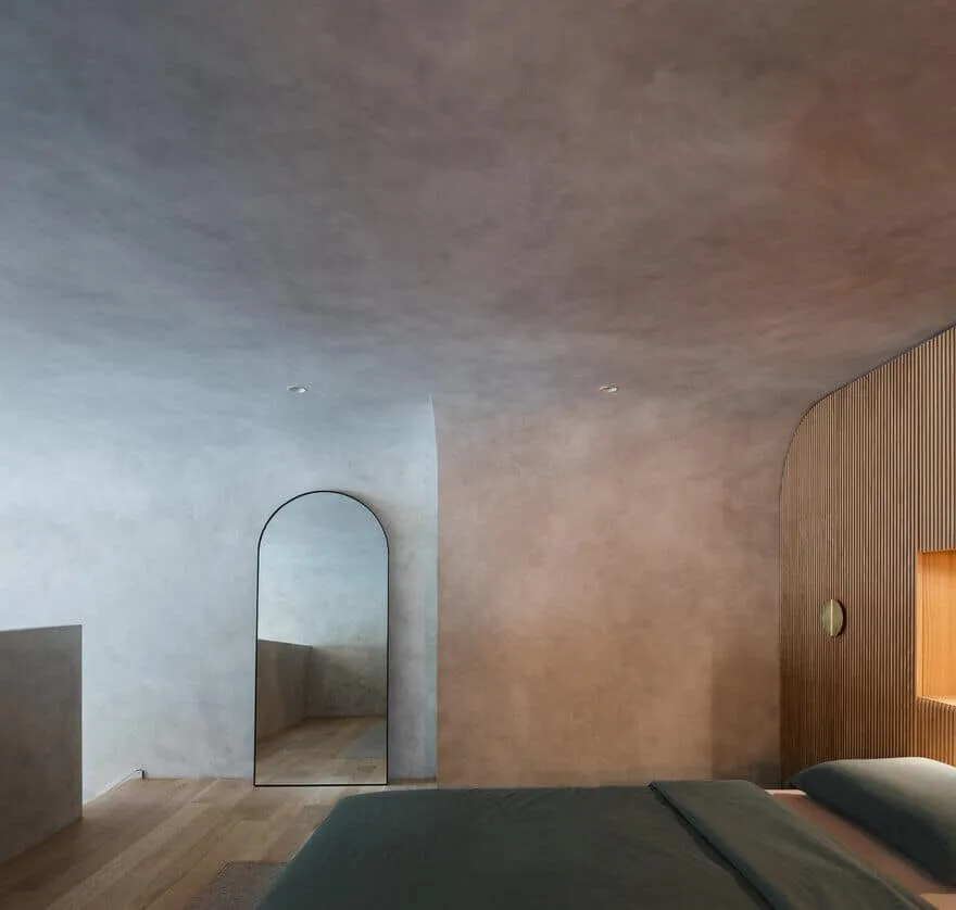 Brutalist bedroom with arched full mirror wall and smooth textured ceiling