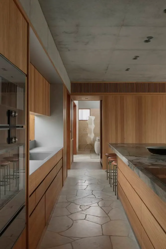 Modern kitchen with wooden cabinetry and stone flooring in Newcastle by Anthony St. John Parsons