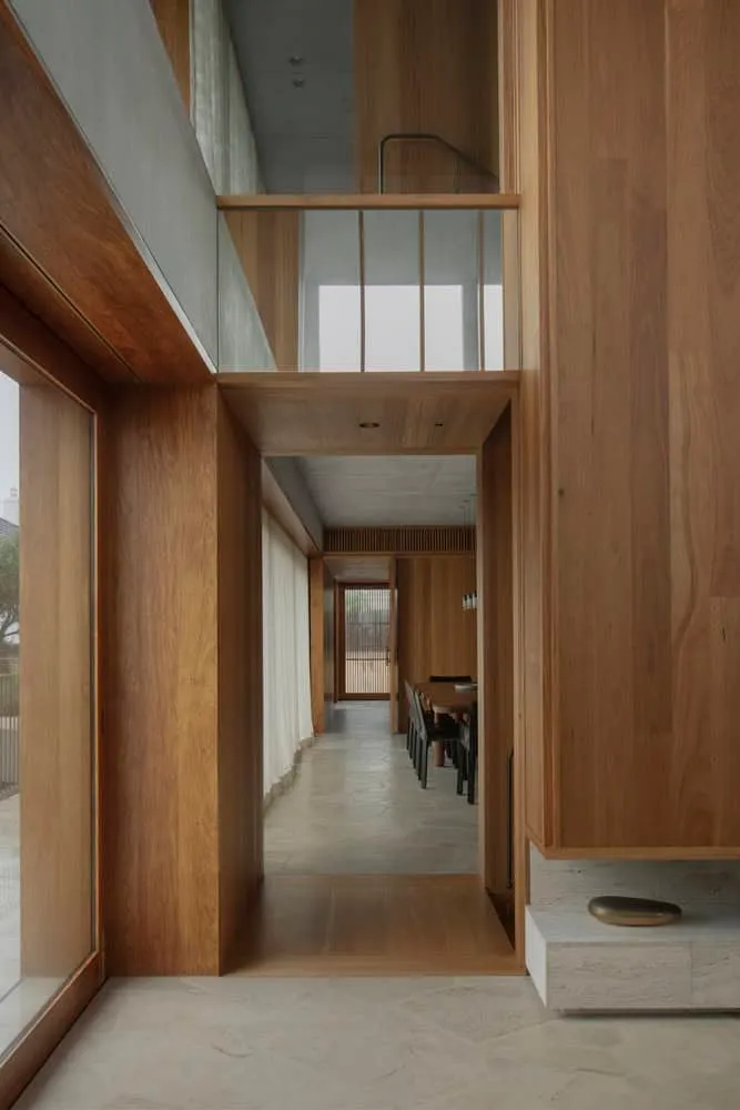 Interior view of double height dining room framed by warm wood in Newcastle home