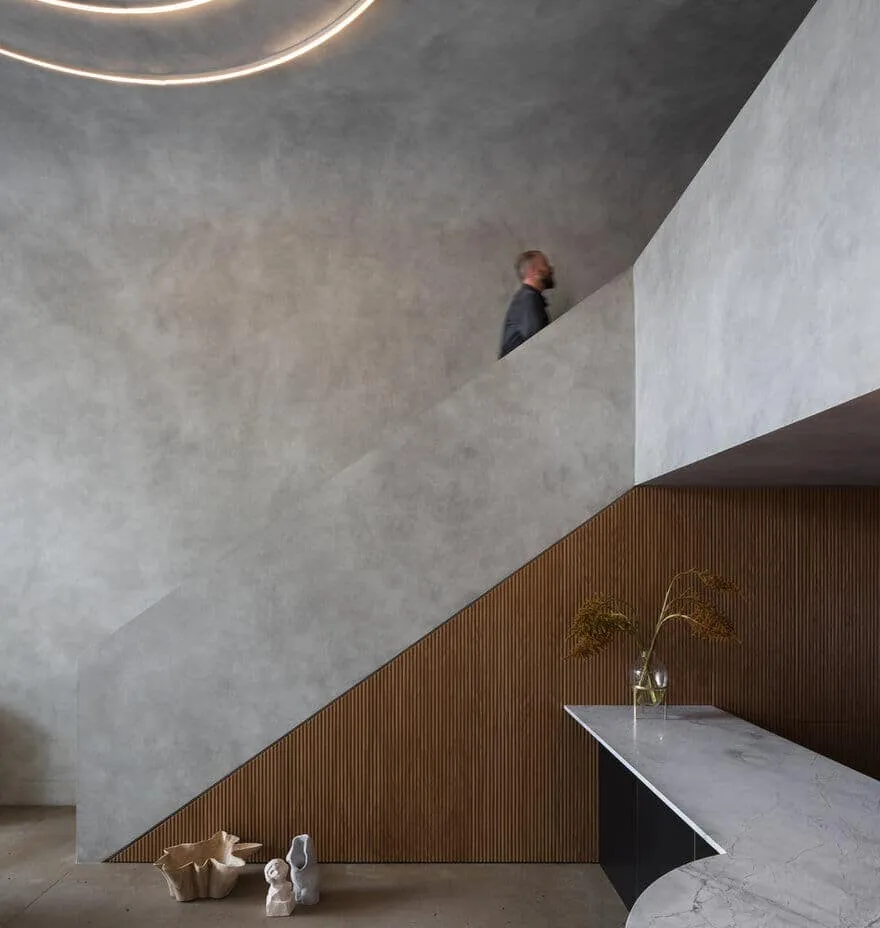 Brutal stairs with textured concrete wall and sculptural lighting