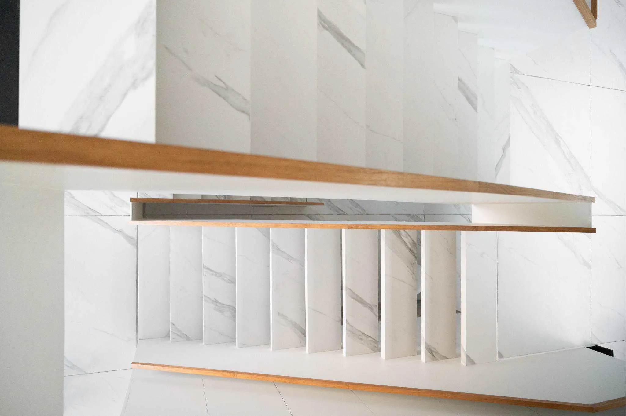 帕切科住宅白色大理石悬浮楼梯与木质扶手特写