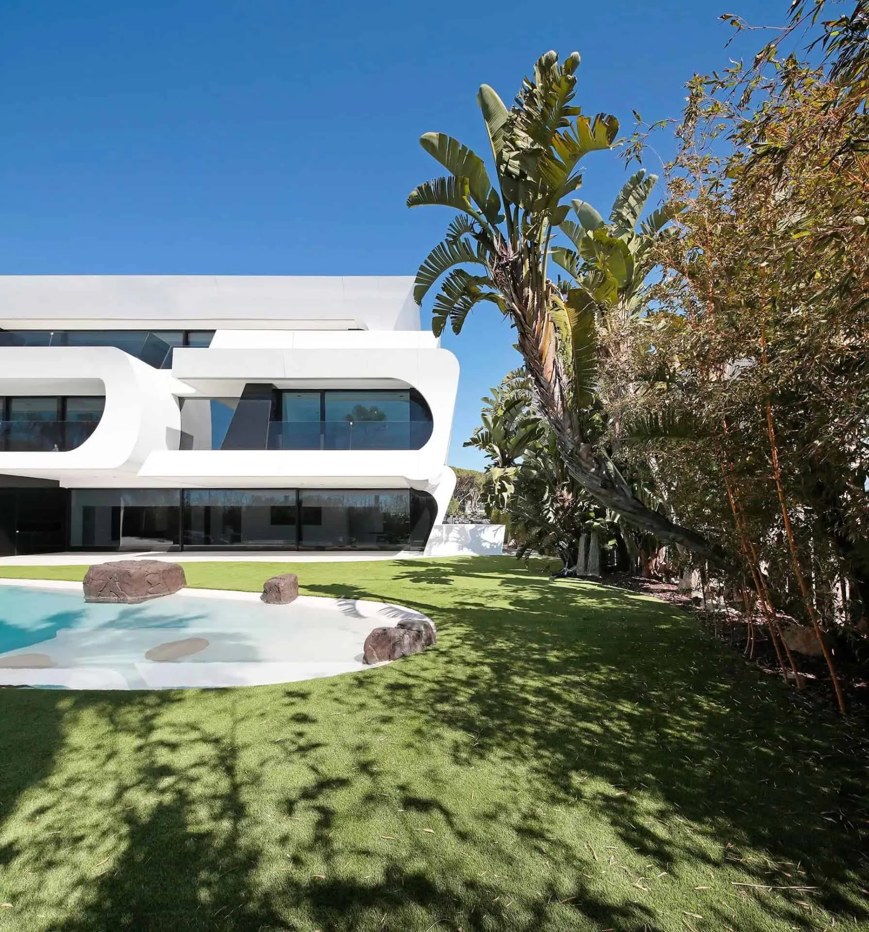 从露台俯瞰泳池、棕榈树和白色瓷砖的全景，展示瓜马尔别墅