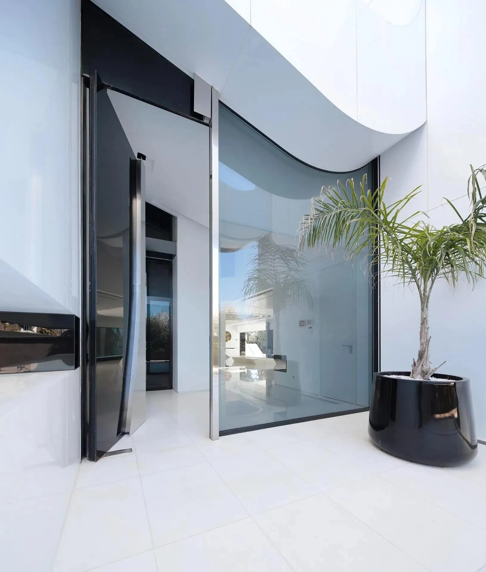 雕塑式入口，配有弯曲玻璃和动态造型的豪华别墅