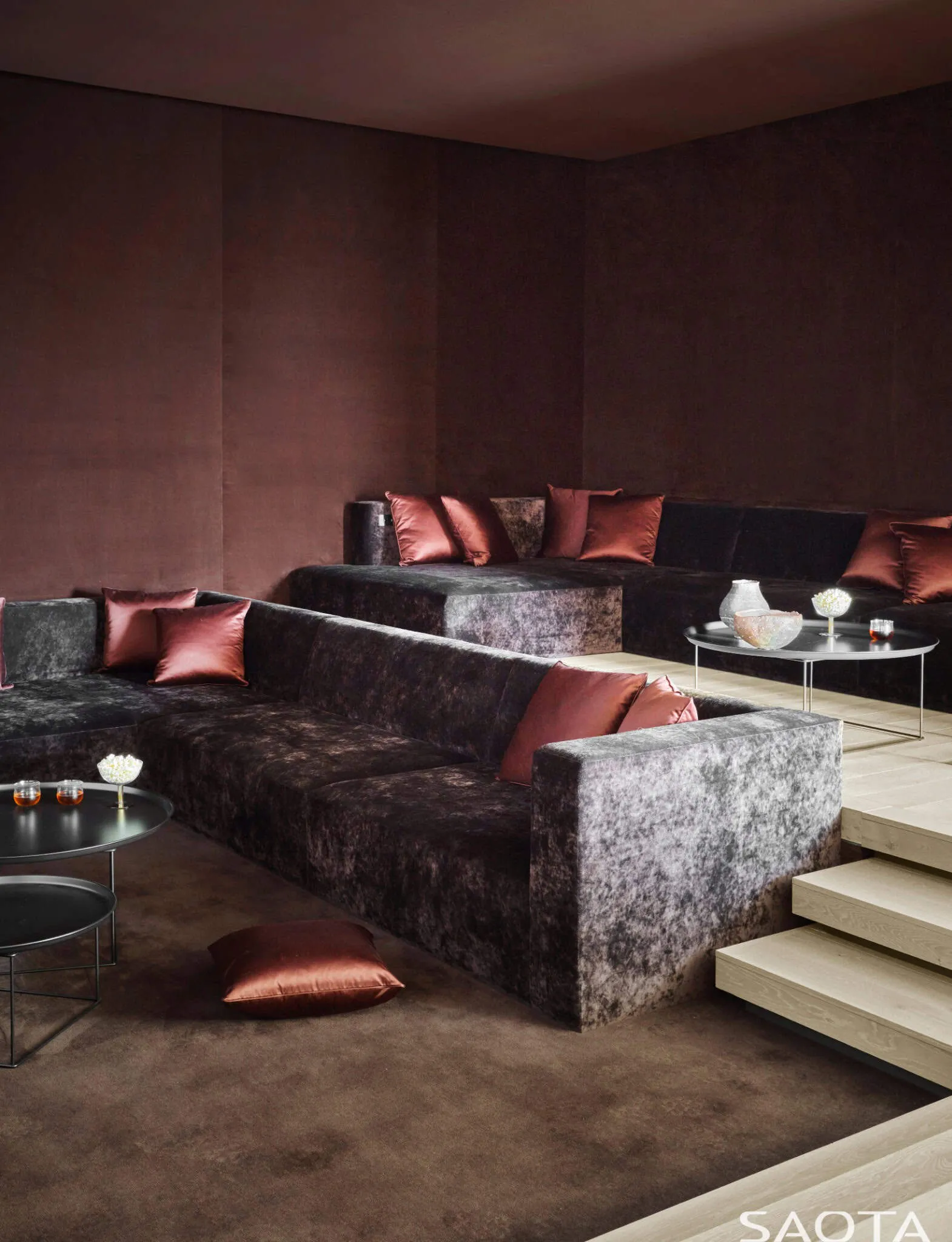 奢华的深紫色影院，设有分层座位和红色靠垫