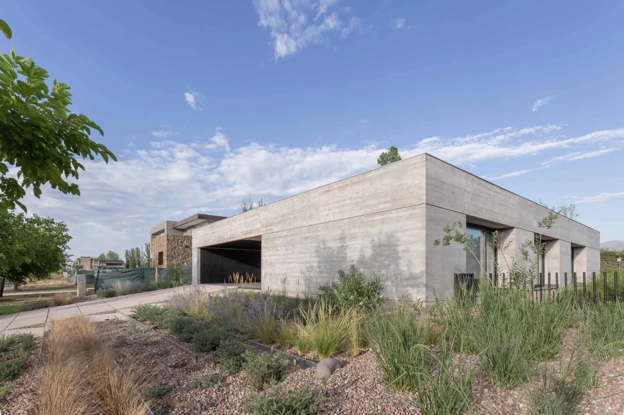 A4estudio设计的Casa Anabela侧车道与绿色植物。