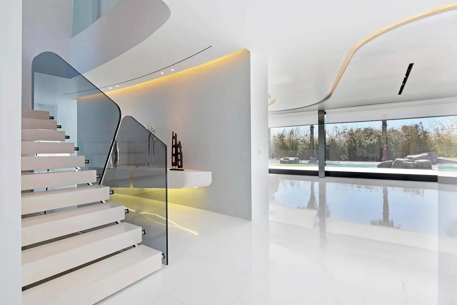 宏伟楼梯，配以明亮红色墙面和弯曲玻璃扶手，展示瓜马尔别墅