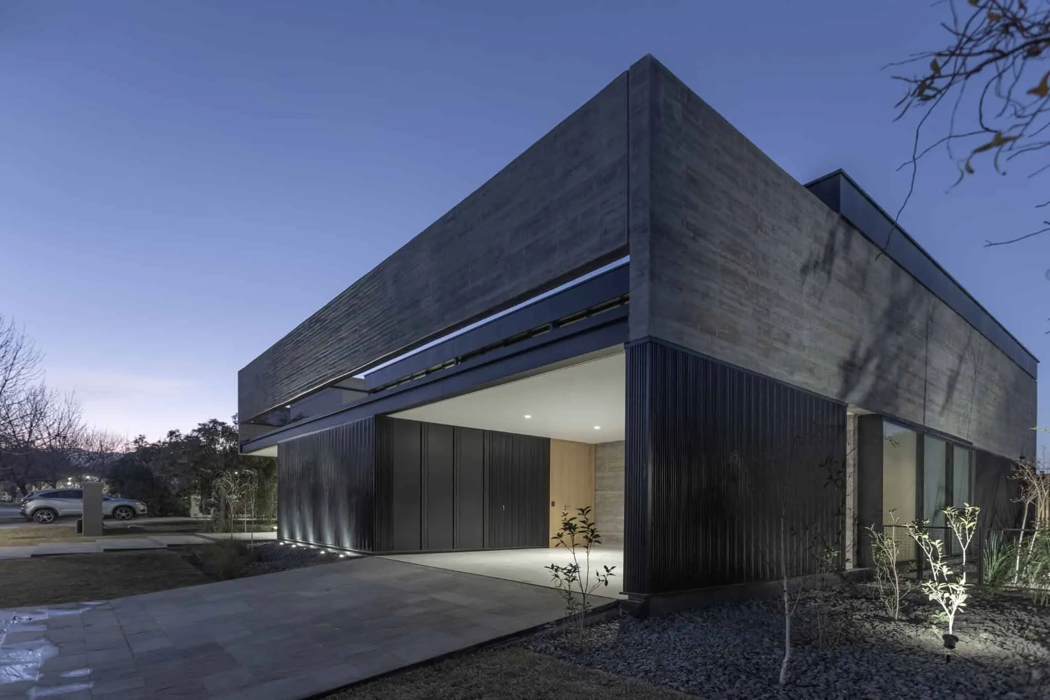 A4estudio设计的Kasa EE：夜间混凝土住宅车库入口