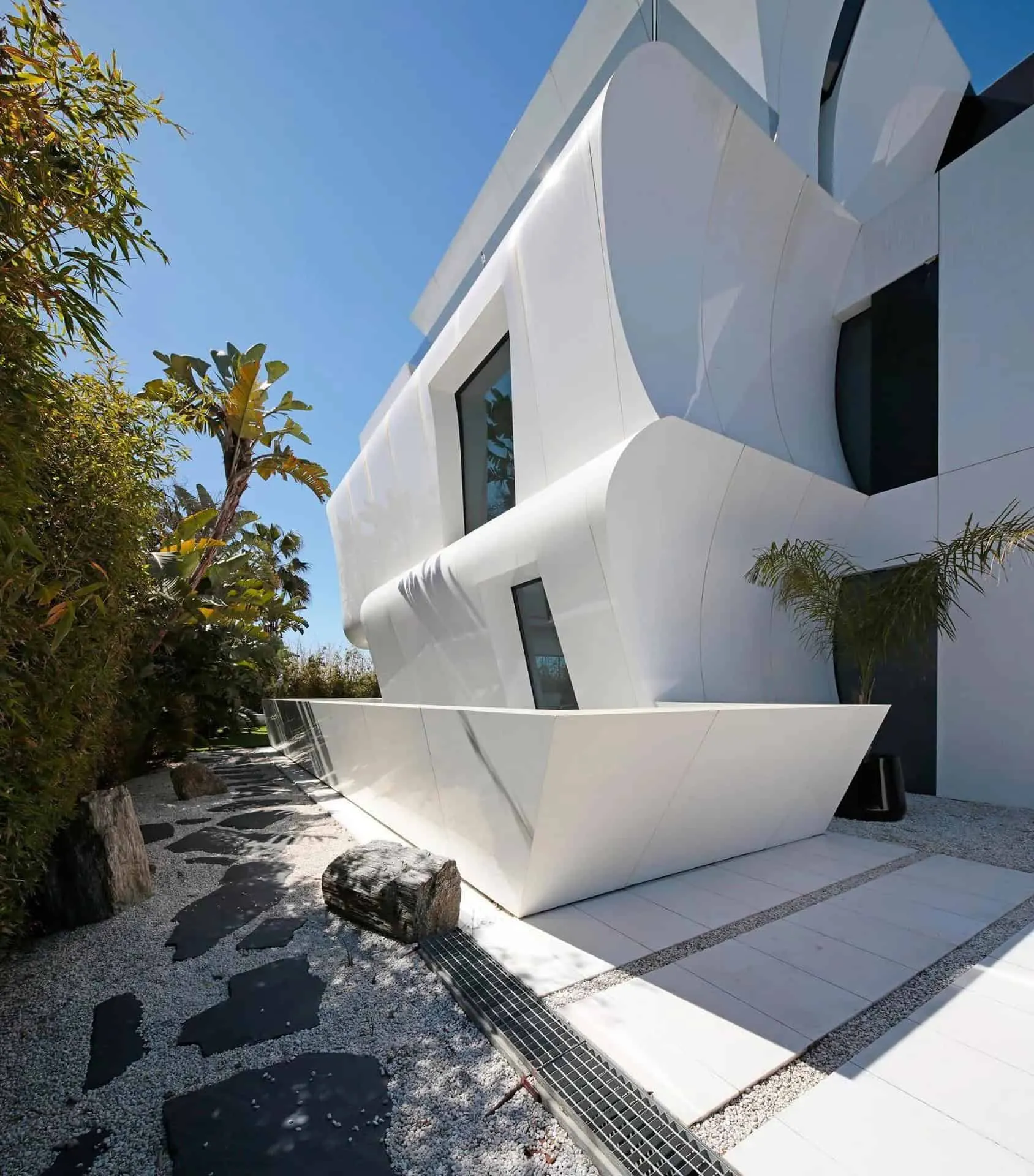 现代极简内饰，配有大窗户和雕塑家具，展示瓜马尔别墅