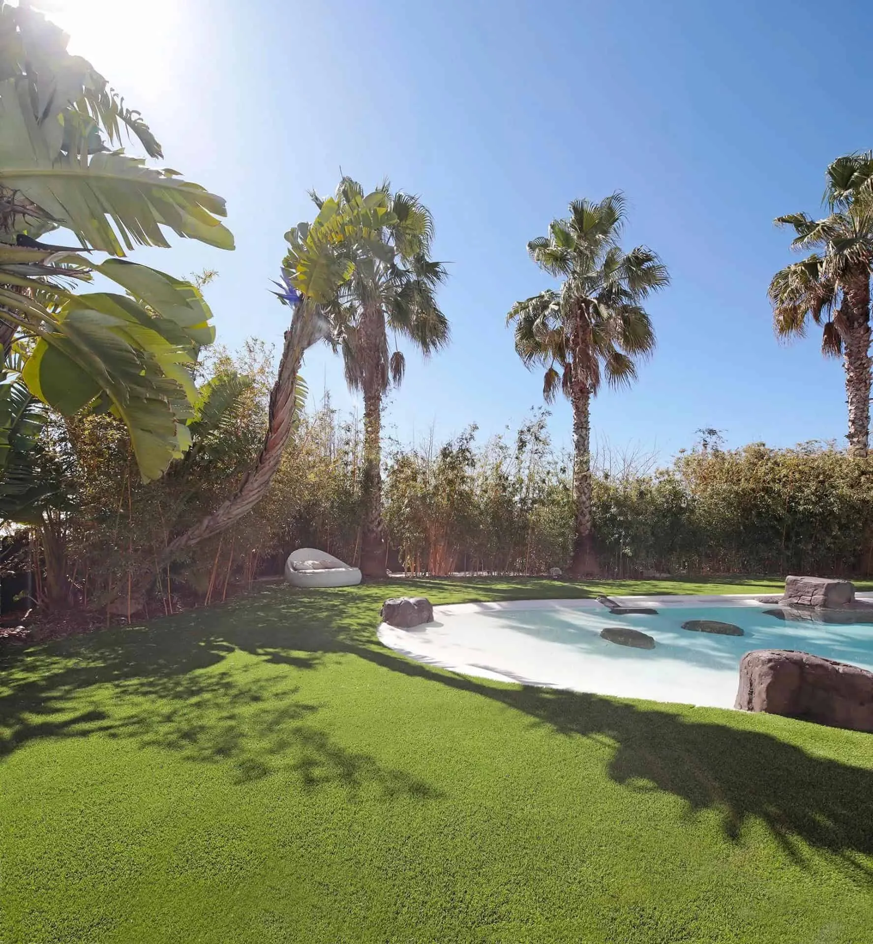 白色三层次未来主义别墅，配有泳池和精心打理的花园