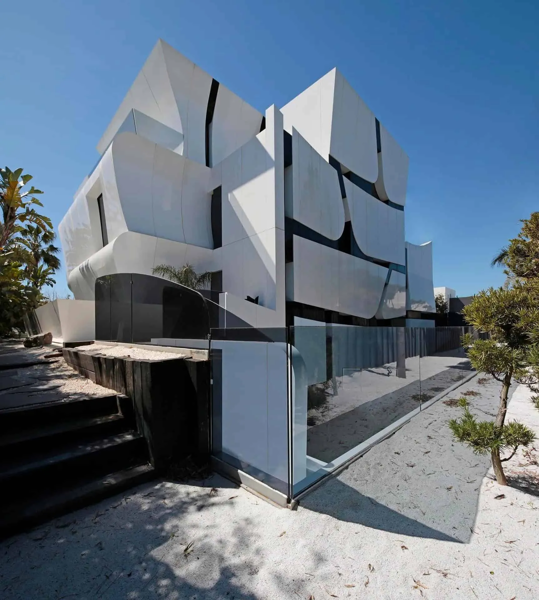 宽敞开放的客厅区域，配有玻璃窗和泳池景观，展示瓜马尔别墅