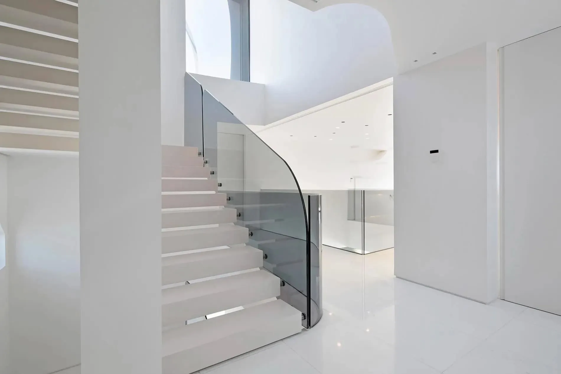 优雅白色楼梯，配有内置灯饰和弯曲建筑结构