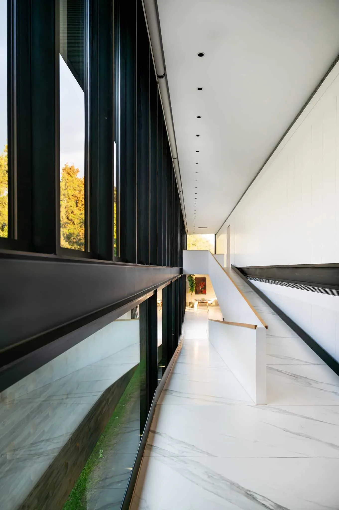 帕切科住宅走廊，柔和晨光照射，两侧为黑色钢窗框