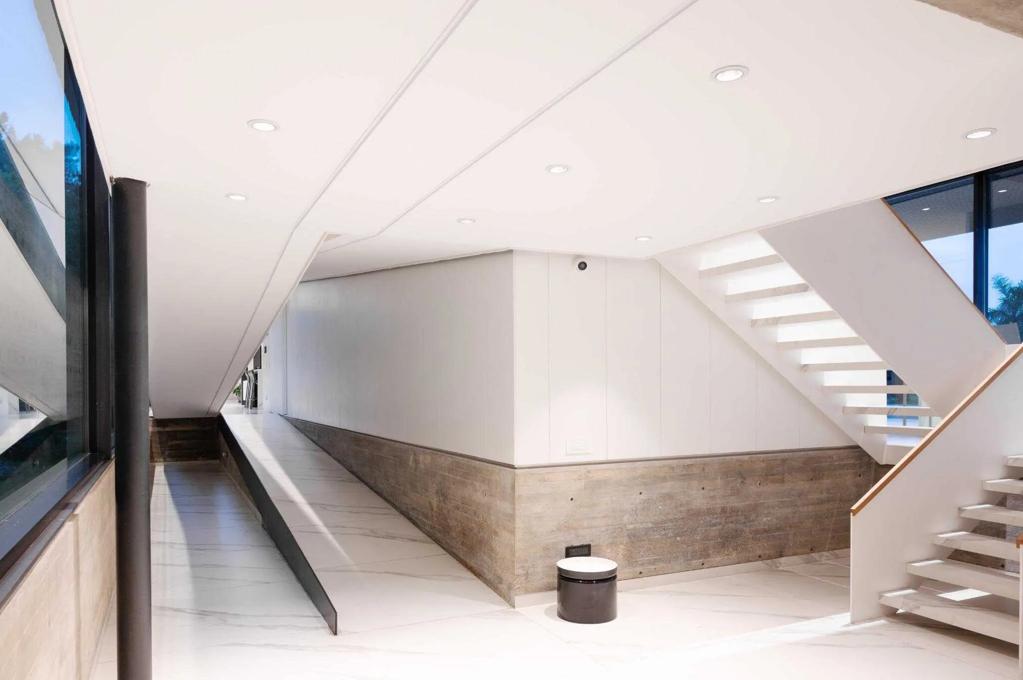 帕切科住宅内部视角，白色楼梯与相邻坡道，内置灯具照明