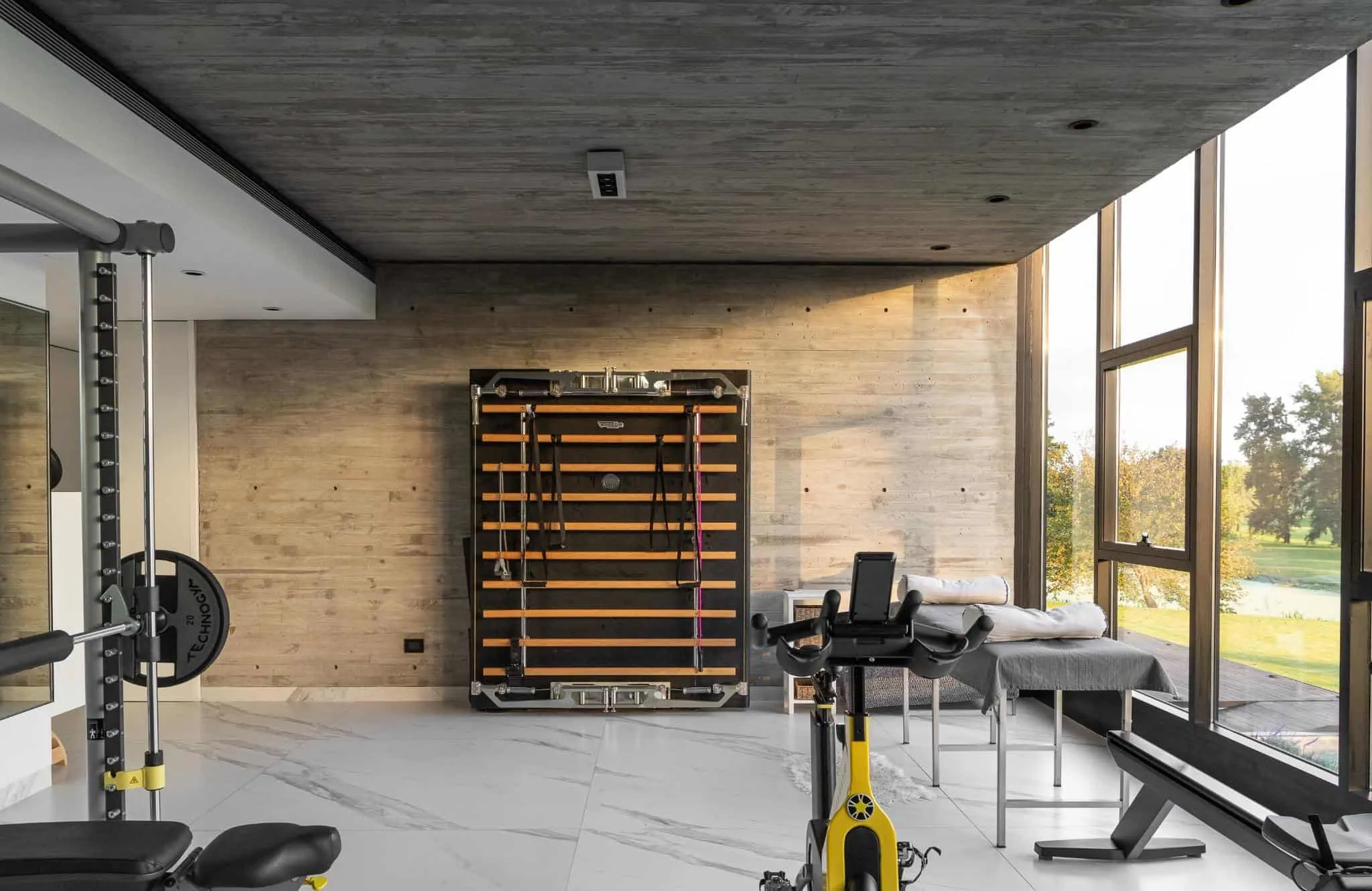 帕切科住宅家庭健身房，配有技术墙面设备与原始混凝土背景