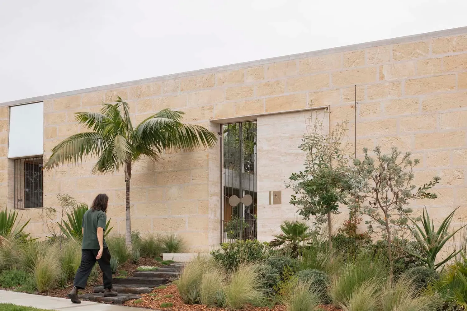 Stone pathway and modern entrance gates surrounded by lush landscape in Newcastle