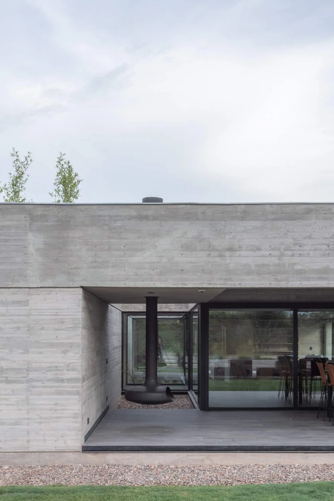 A4estudio设计的Casa Anabela玻璃角落悬挂壁炉。