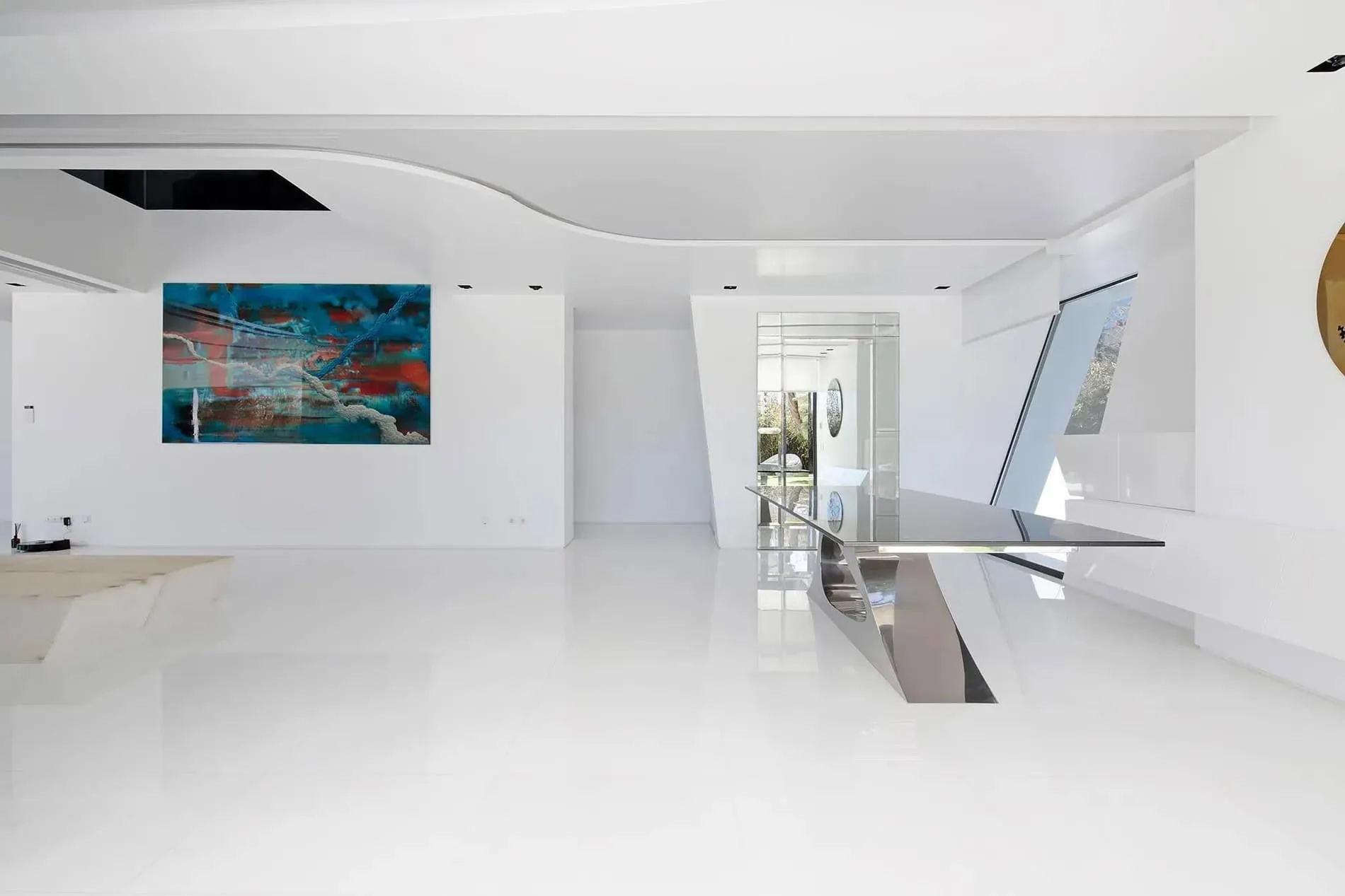 现代白色楼梯，靠近弯曲玻璃窗，展示瓜马尔别墅内饰