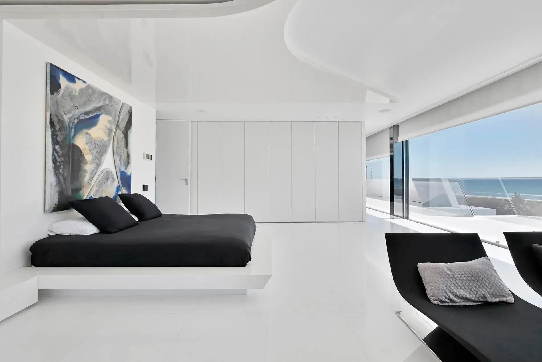 全景海景卧室，配有极简内饰，展示瓜马尔别墅