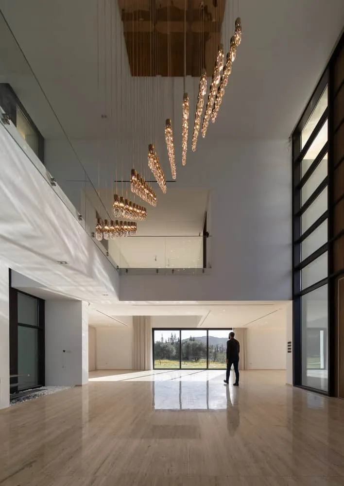 Suspended light sculpture in double-height corridor of Villa Air