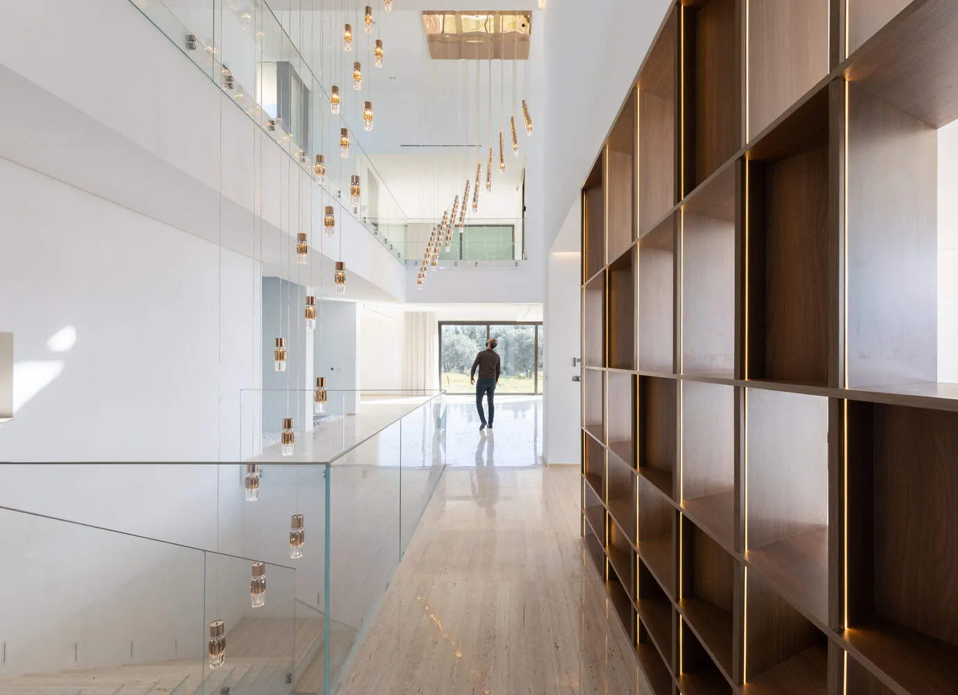 Long corridor with glass balcony and gold pendant lights