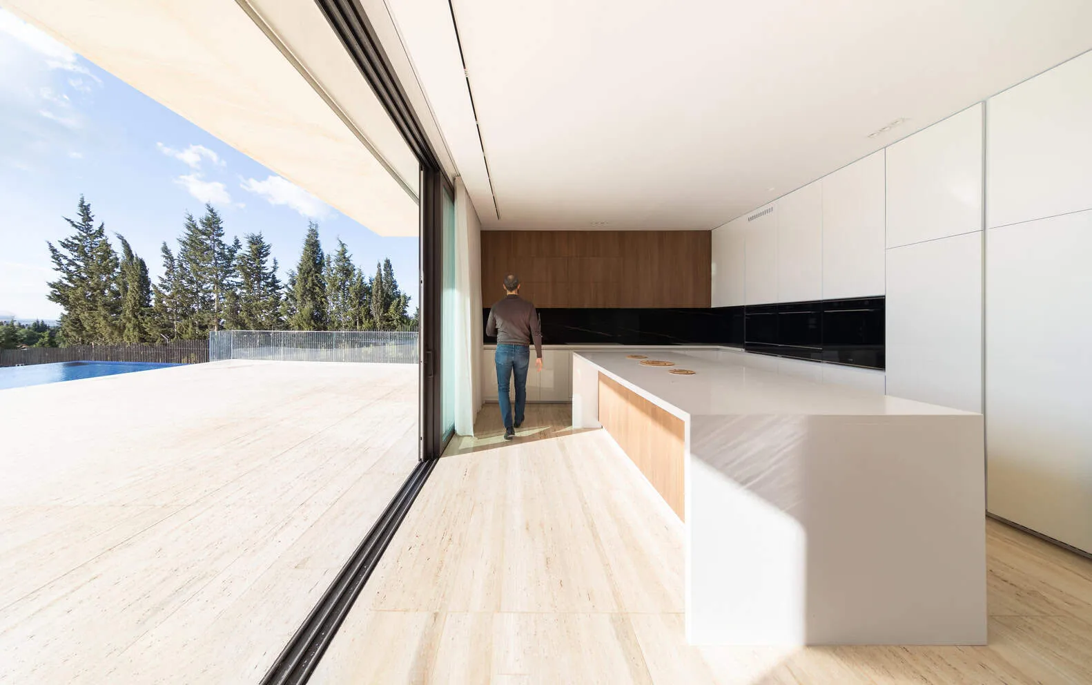Open kitchen with wooden and white finishes leading to terrace