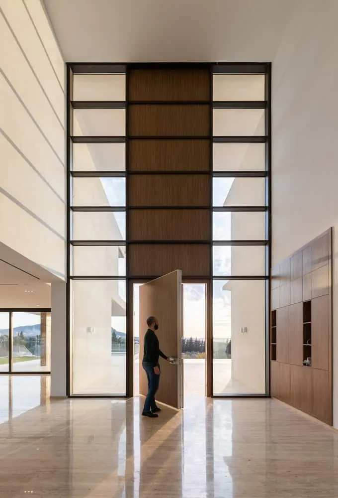 Impressive high entrance door with wooden and glass facade