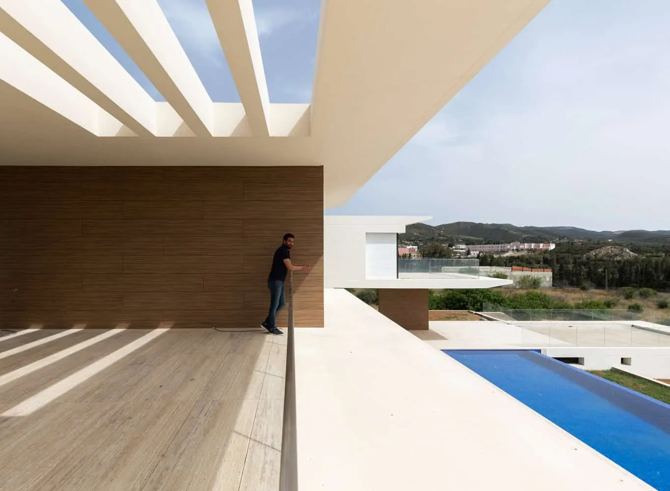 Detail of pergola on balcony with pool and hills in the background