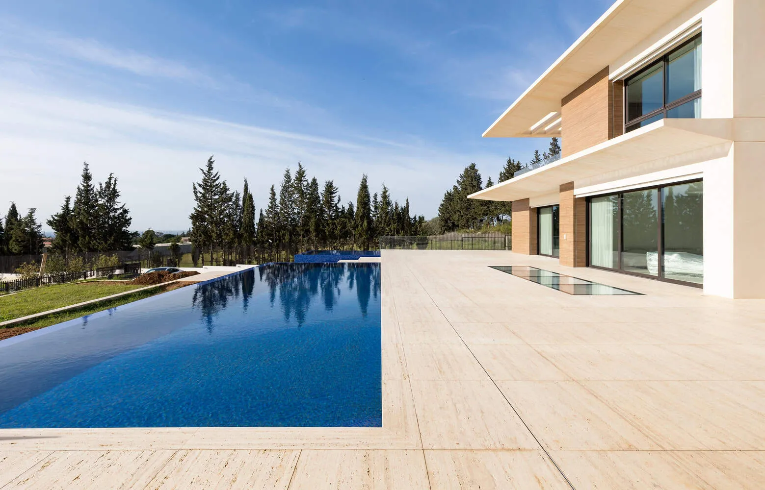 Large infinity pool reflecting modern lines of Villa Air