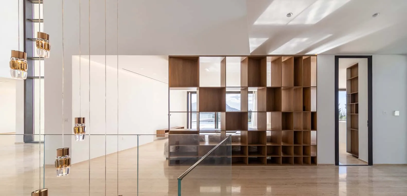 Wooden bookshelf reaching double-height ceiling with grid detailing