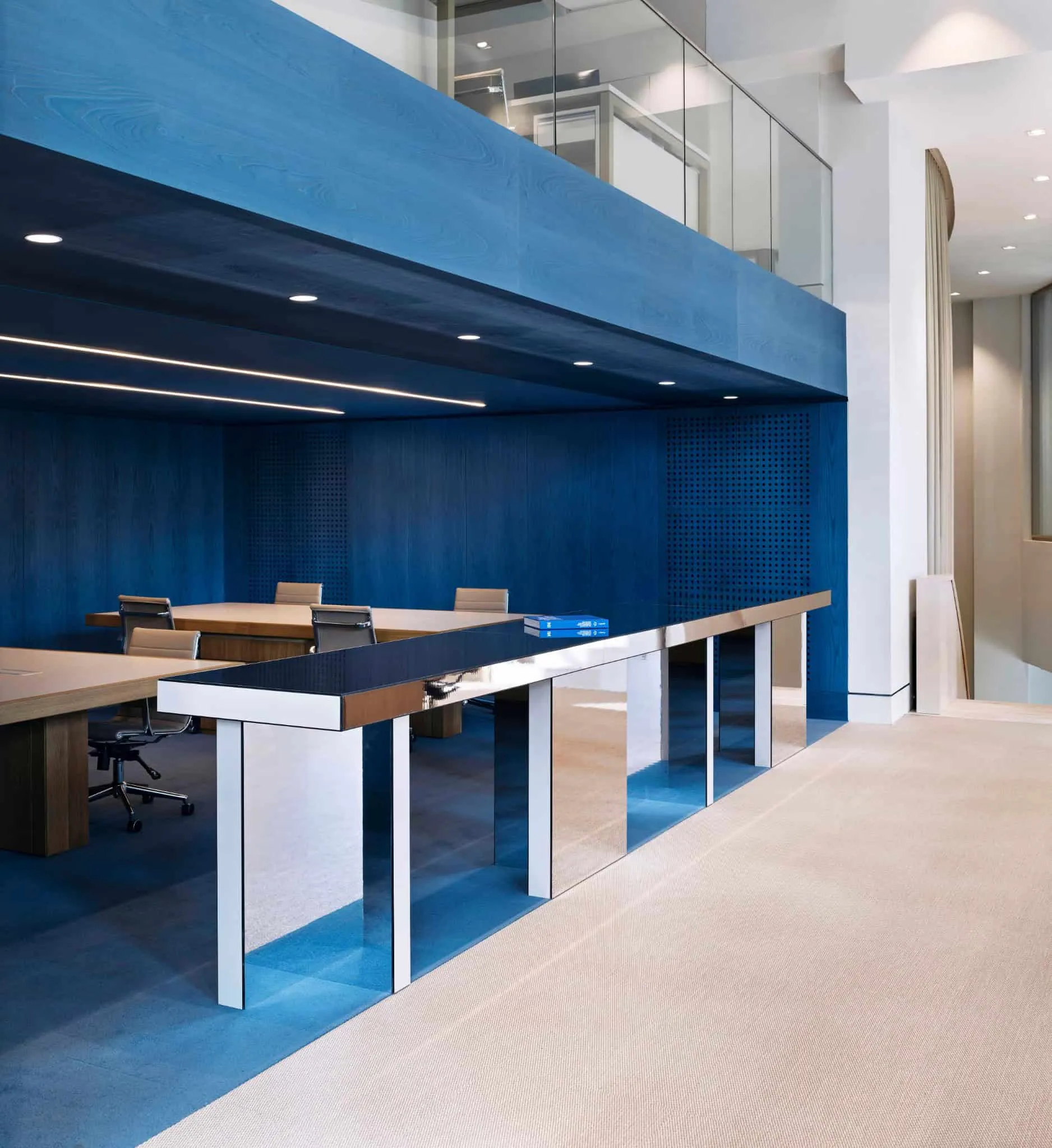 Custom mirror table and detail of blue wood wall in Özlenir Headquarter by URBANJOBS