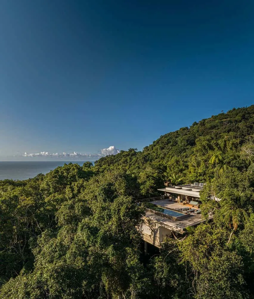 Aerial view of Canopy House by Studio MK27, surrounded by dense forest in Guarujá, Brazil