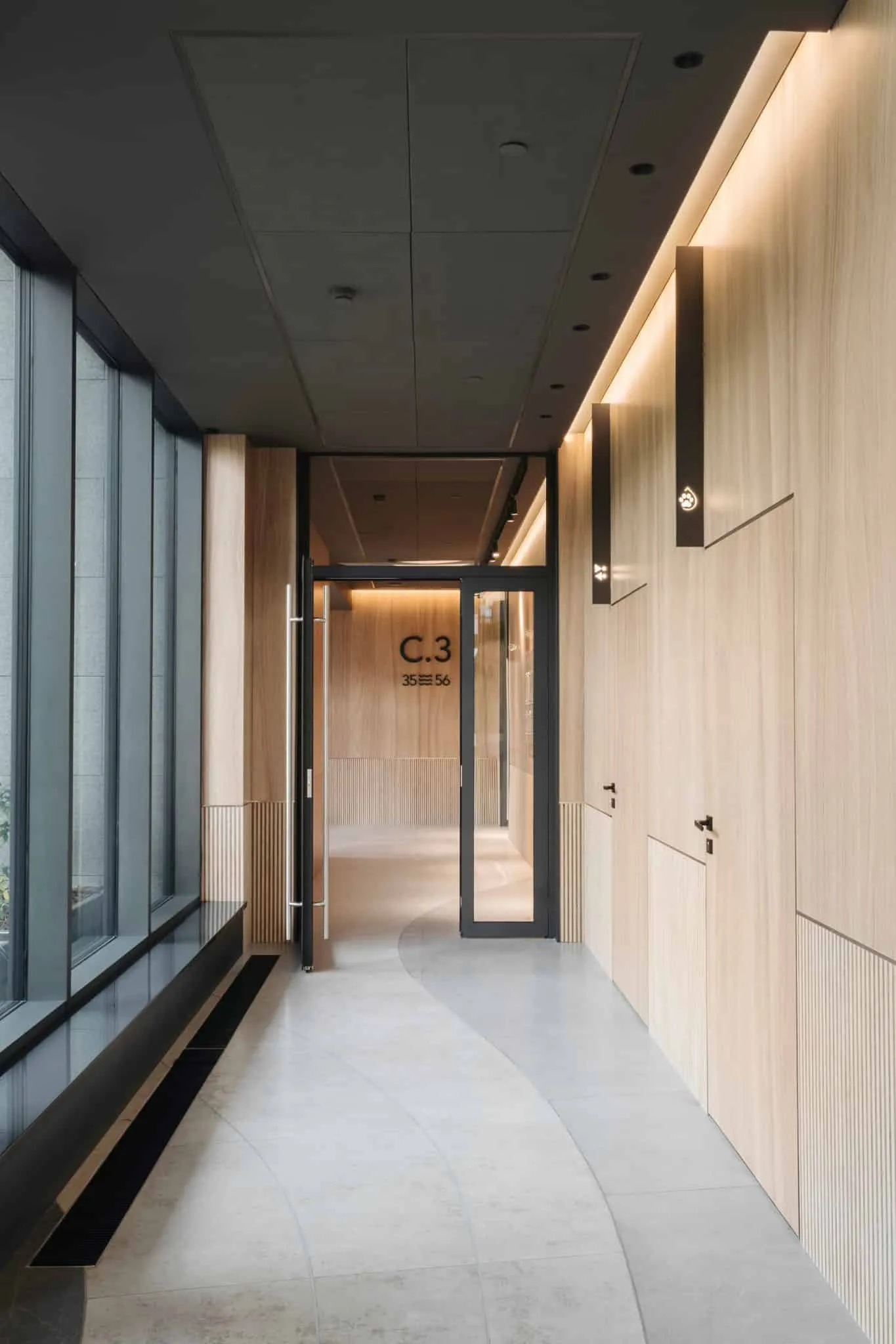 Modern minimalist interior with elegant wooden cladding, contemporary lighting and large glass windows for natural light, ideal for architectural projects and modern interiors.