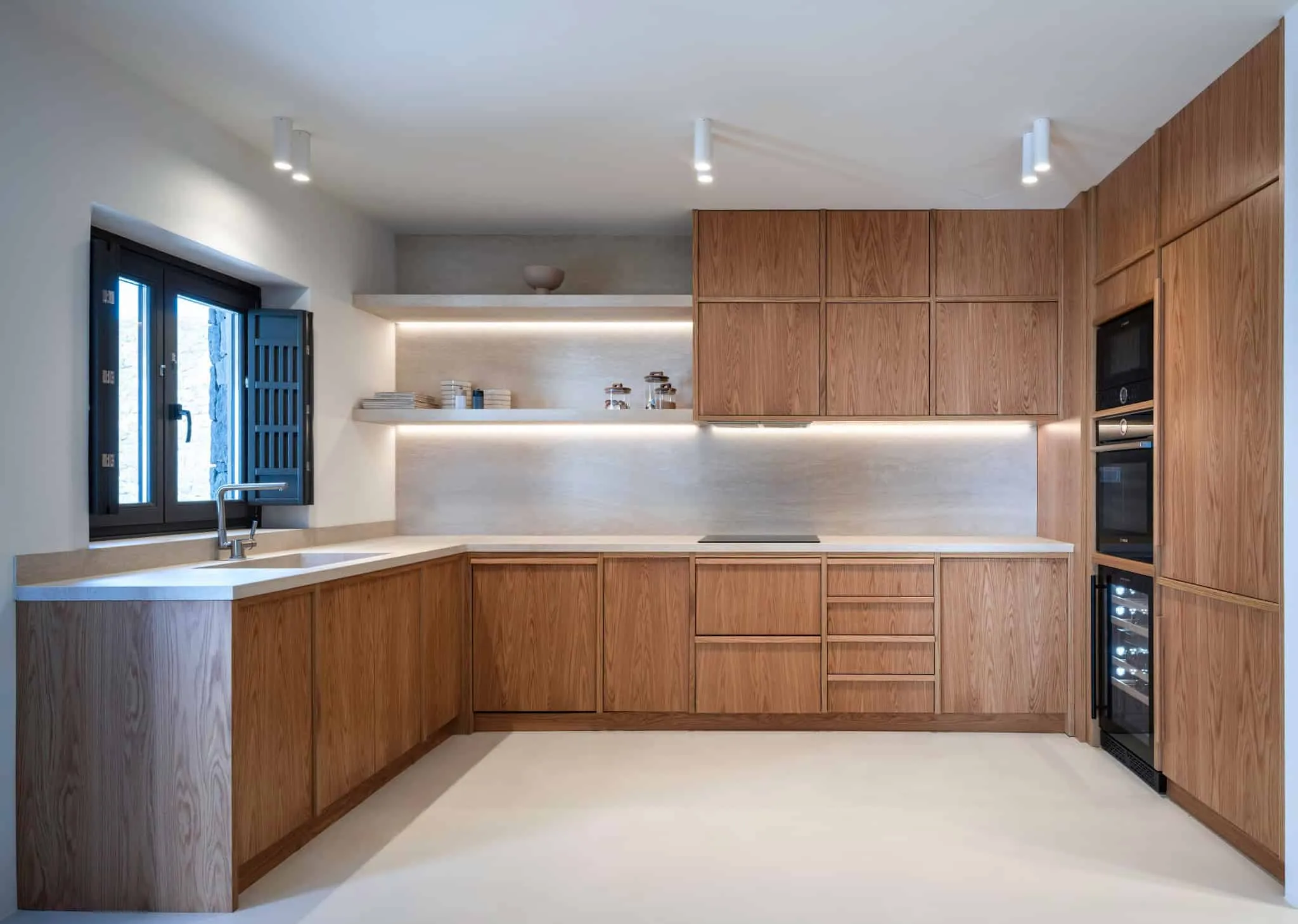 KKMK Architects拍摄的白 magma 房屋带木质家具厨房，圣托里尼