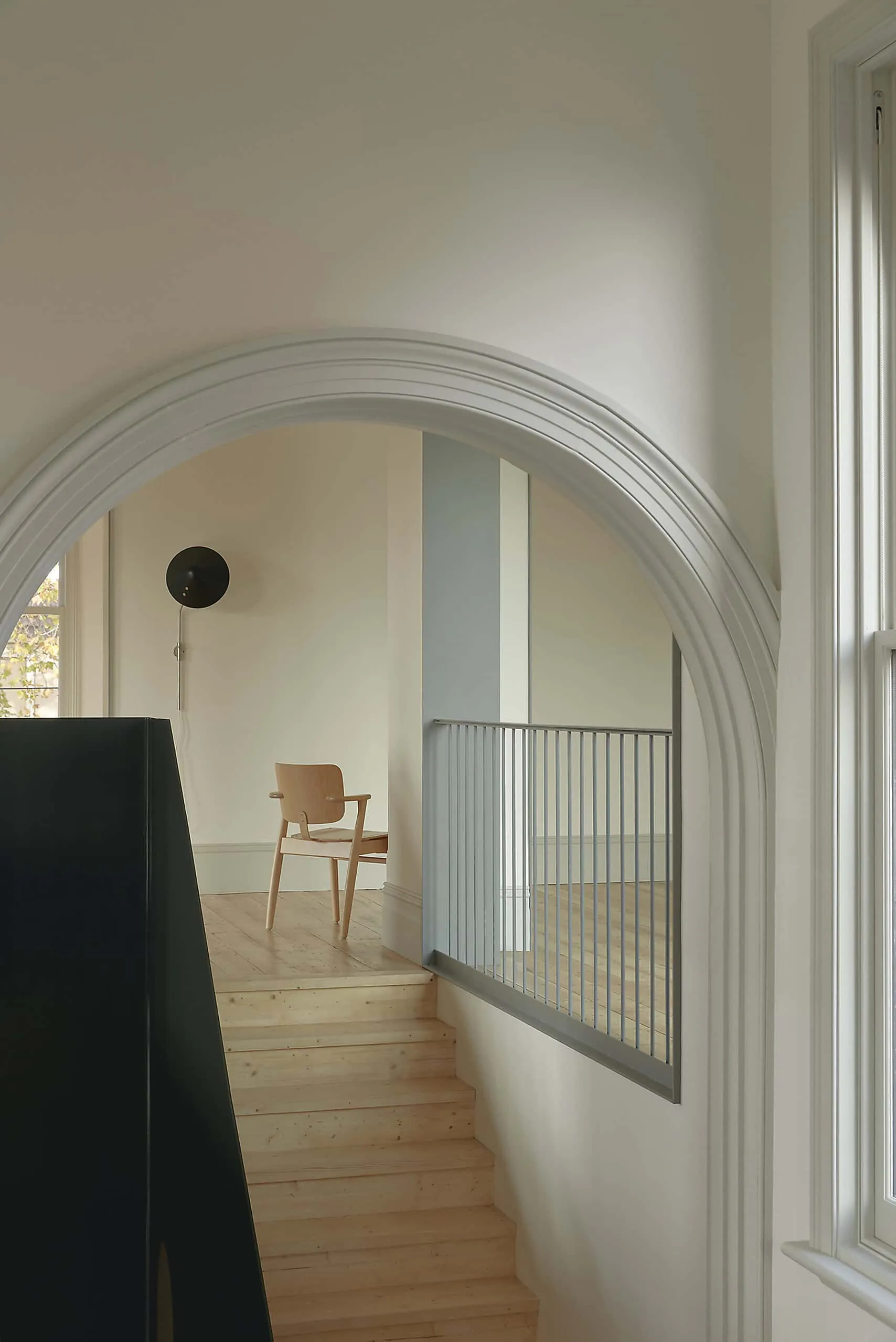 Elegant architectural design interior with arched doors, minimalist staircase and natural light highlighting modern architecture and stylish interior.