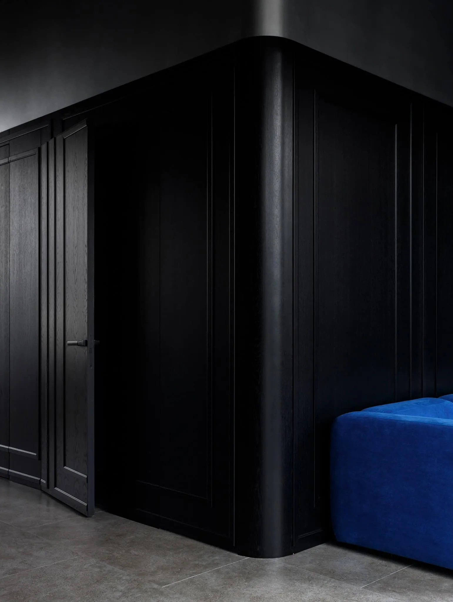 Modern minimalist interior by Julia Starikova – dark wall section and blue sofa in Chelyabinsk, Russia