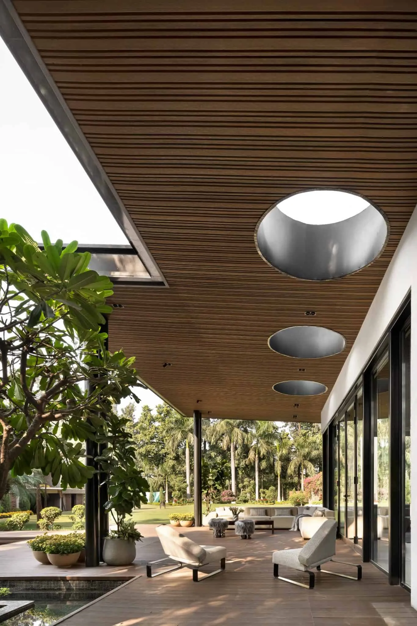 Relaxation spot on the terrace in UrbanMistrii's Pool House in Chatarpur, Delhi.