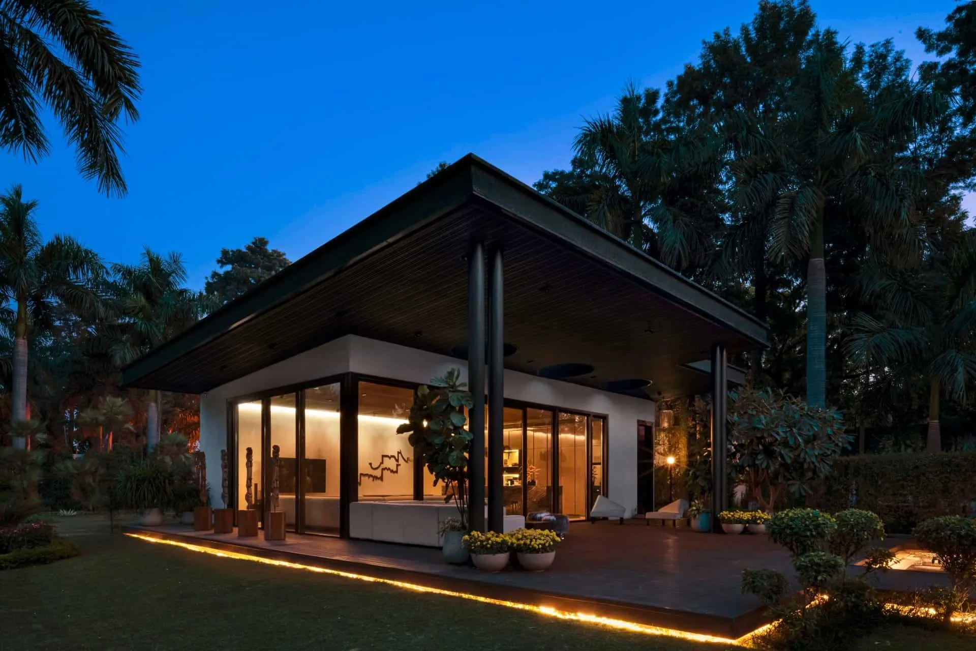 Exterior view of UrbanMistrii's Pool House at sunset in Chatarpur, Delhi.