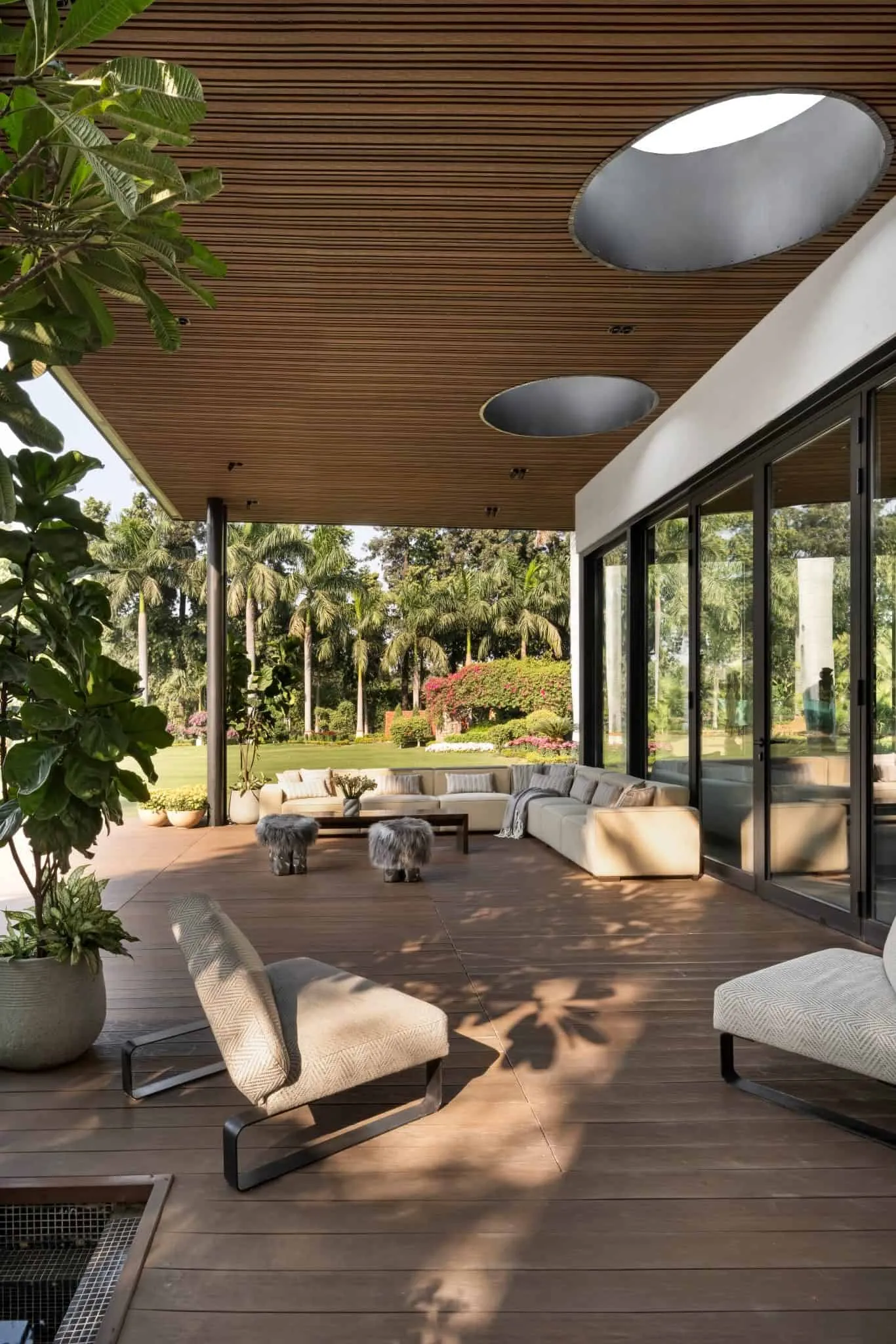 Lounge area on the lawn in UrbanMistrii's Pool House in Chatarpur, Delhi.