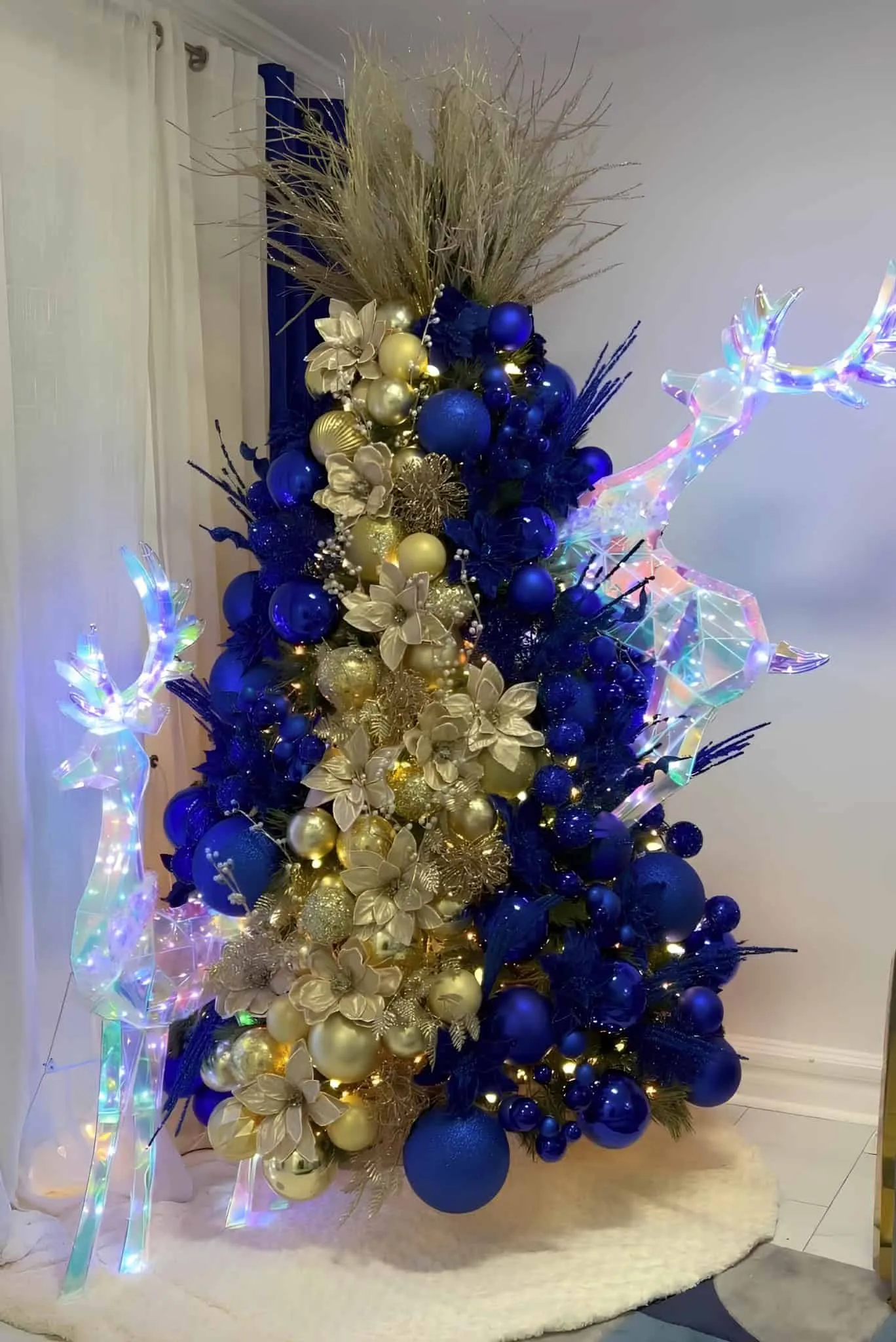 皇室蓝金圣诞树，装饰着LED驯鹿、金属花和发光饰品