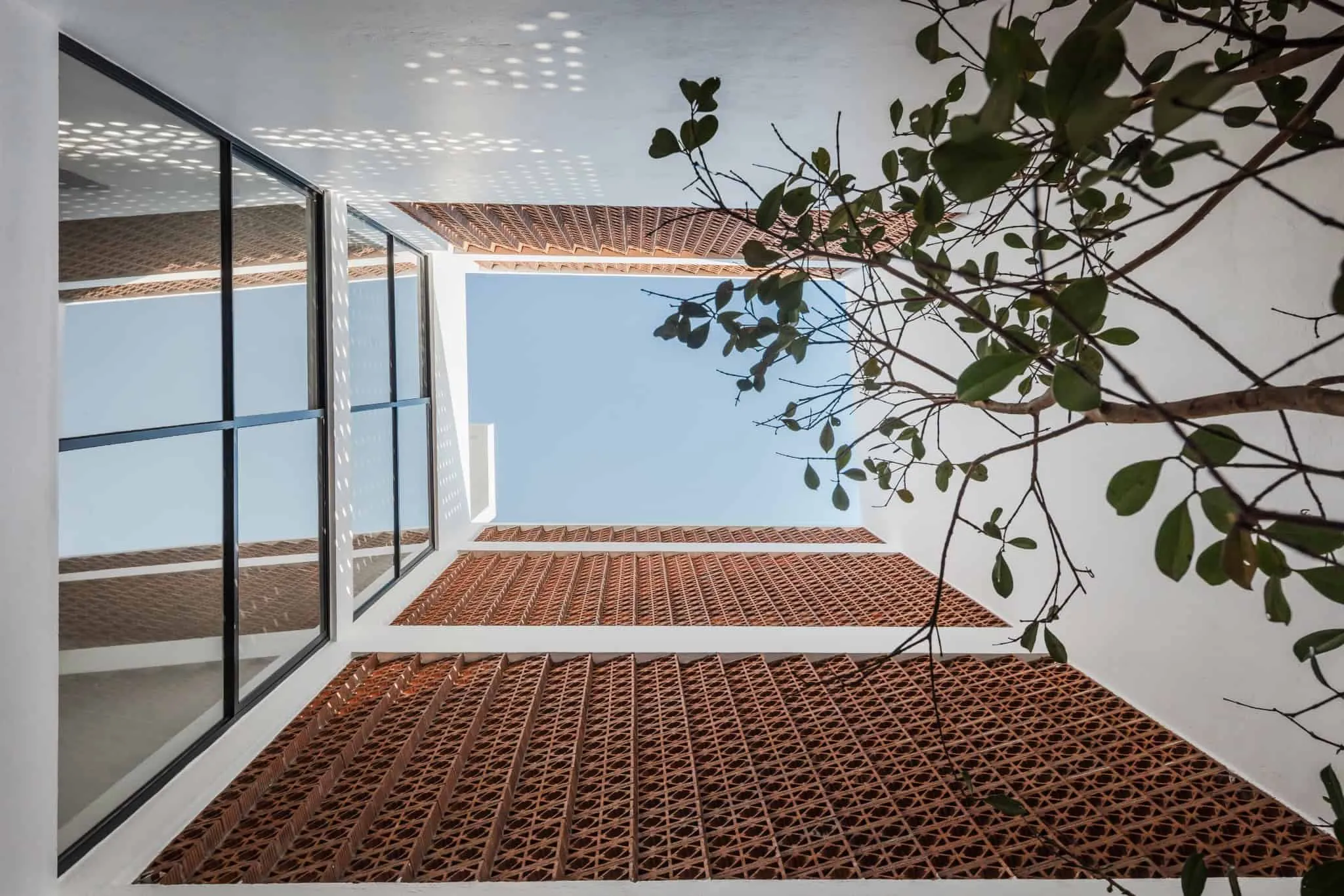 MM34 – Мар Медитерранео 34 от Ателье Инка Эрнандес — кирпичные решетки двора и вид на небо, Такуба, Мехико