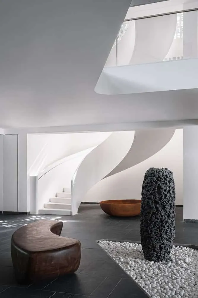 House NINE X NINE — lobby with sculptural staircase and stone sculpture in Gandhinagar