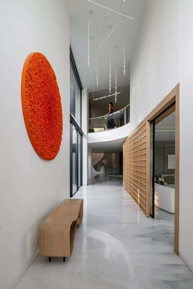 Two-story gallery with chandeliers and balcony in House NINE X NINE in Gandhinagar