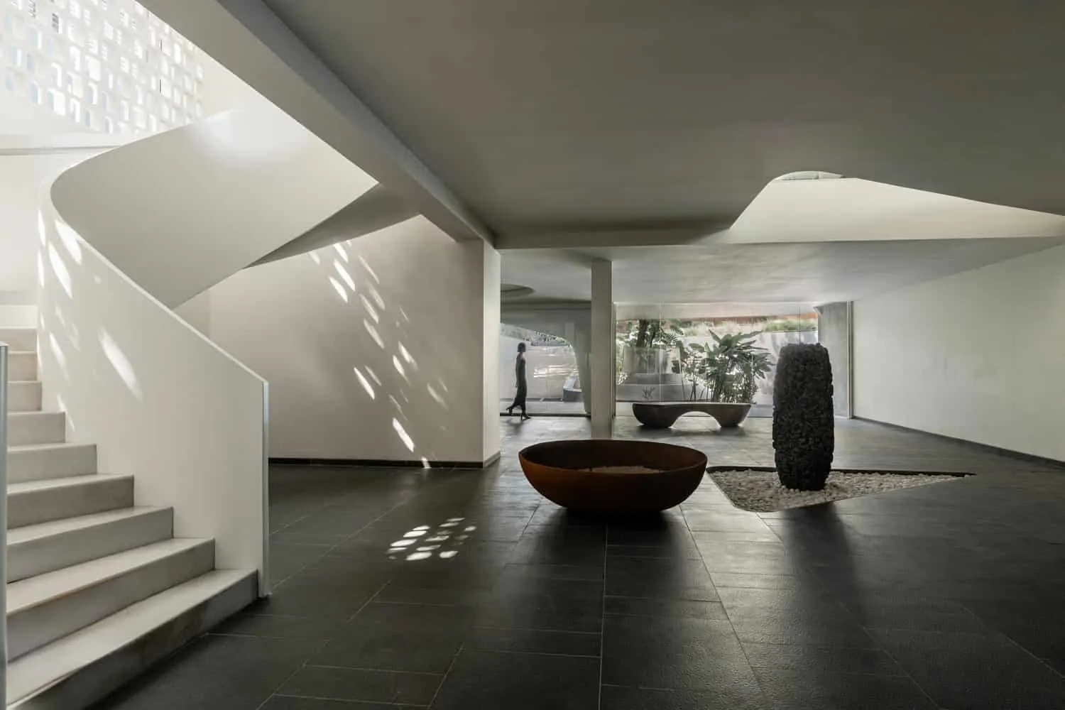 Interior lobby with sculptural staircase and artworks in House NINE X NINE in Gandhinagar