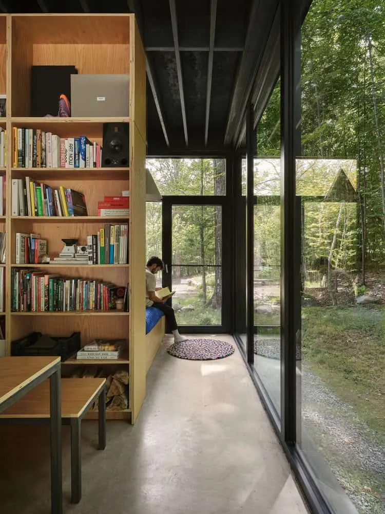 Maison Spiron — coin lecture et bibliothèque avec fenêtre jusqu’au plafond à Potton, Québec, Canada