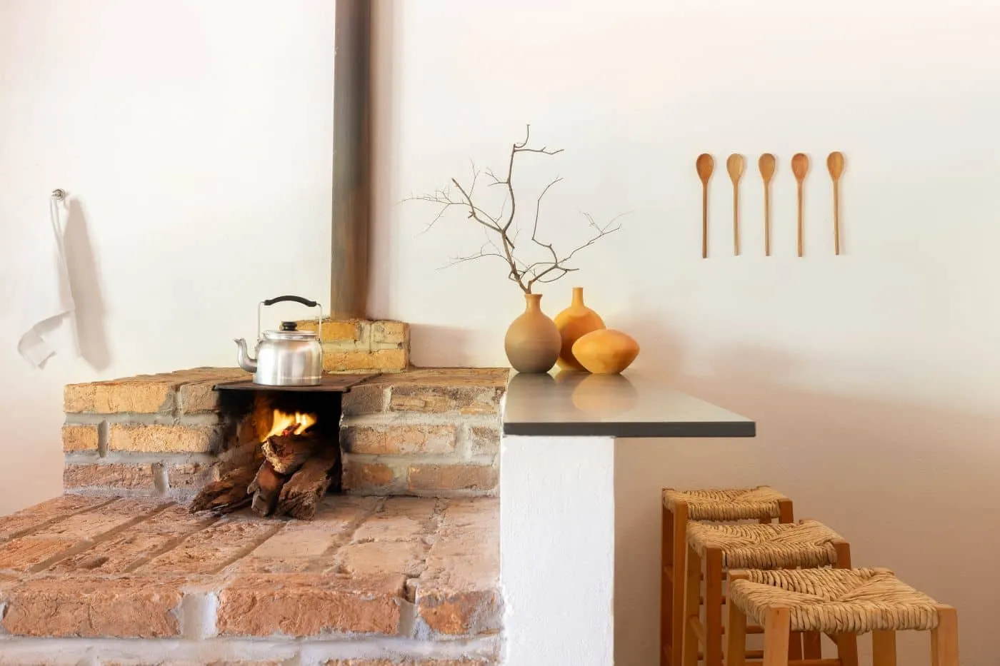 Refúgio Rural — brick fireplace with stone countertop and stained glass chairs in Itajobi, São Paulo