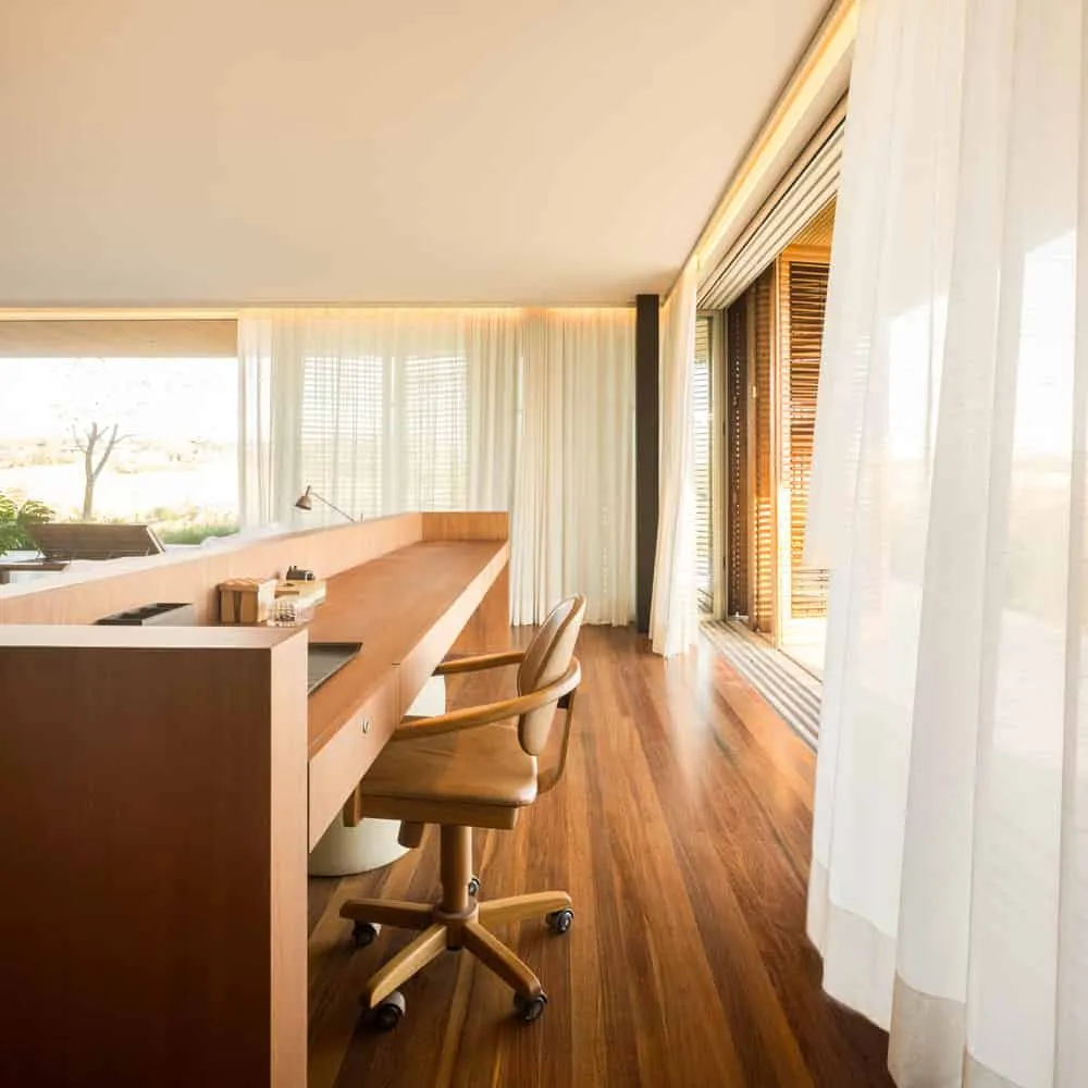 House TM – corner workspace with curtains and wooden floor, Brazil