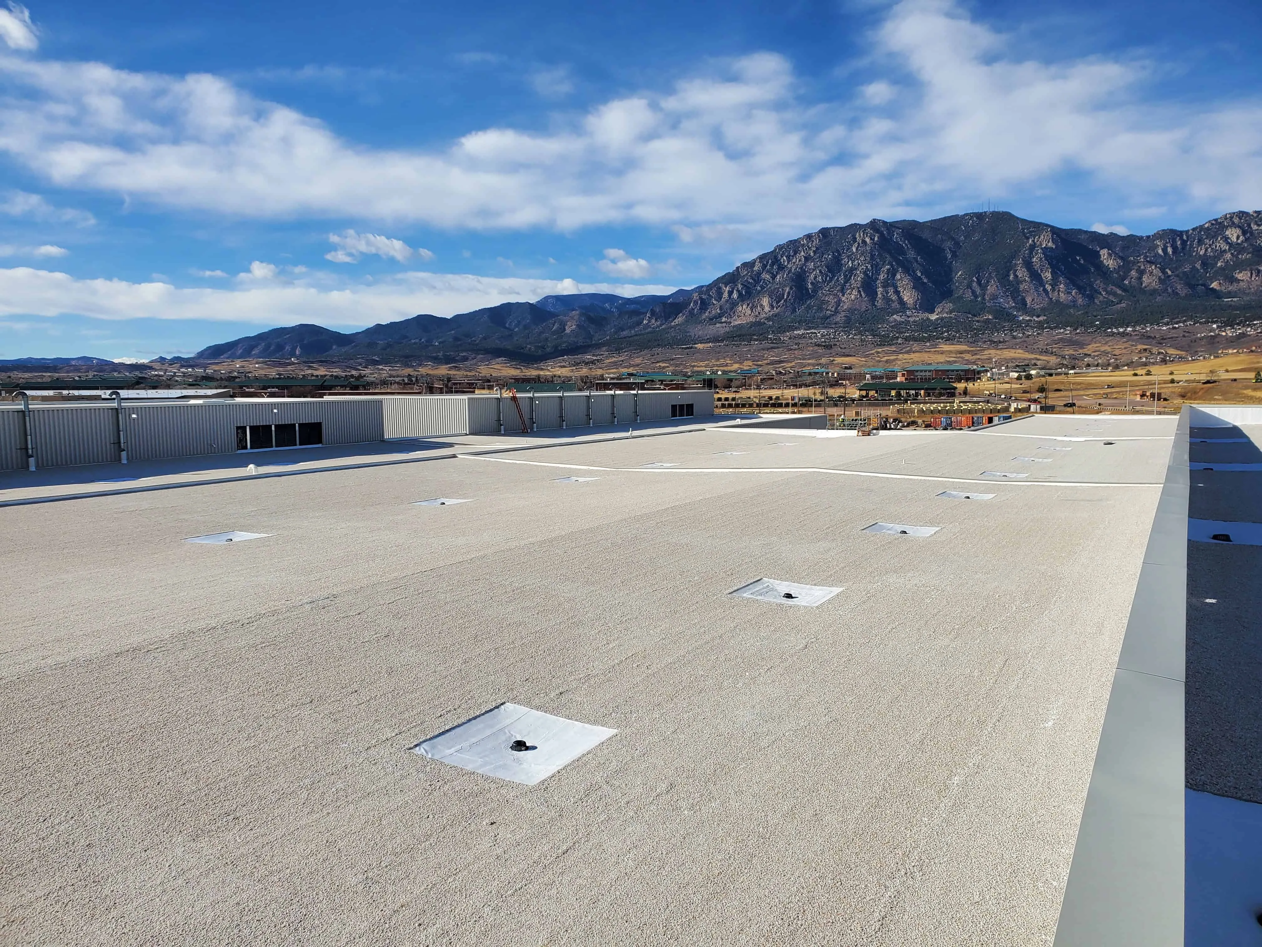 Commercial flat roof with built-up roofing system – multiple layers of asphalt and gravel for strength and waterproofing
