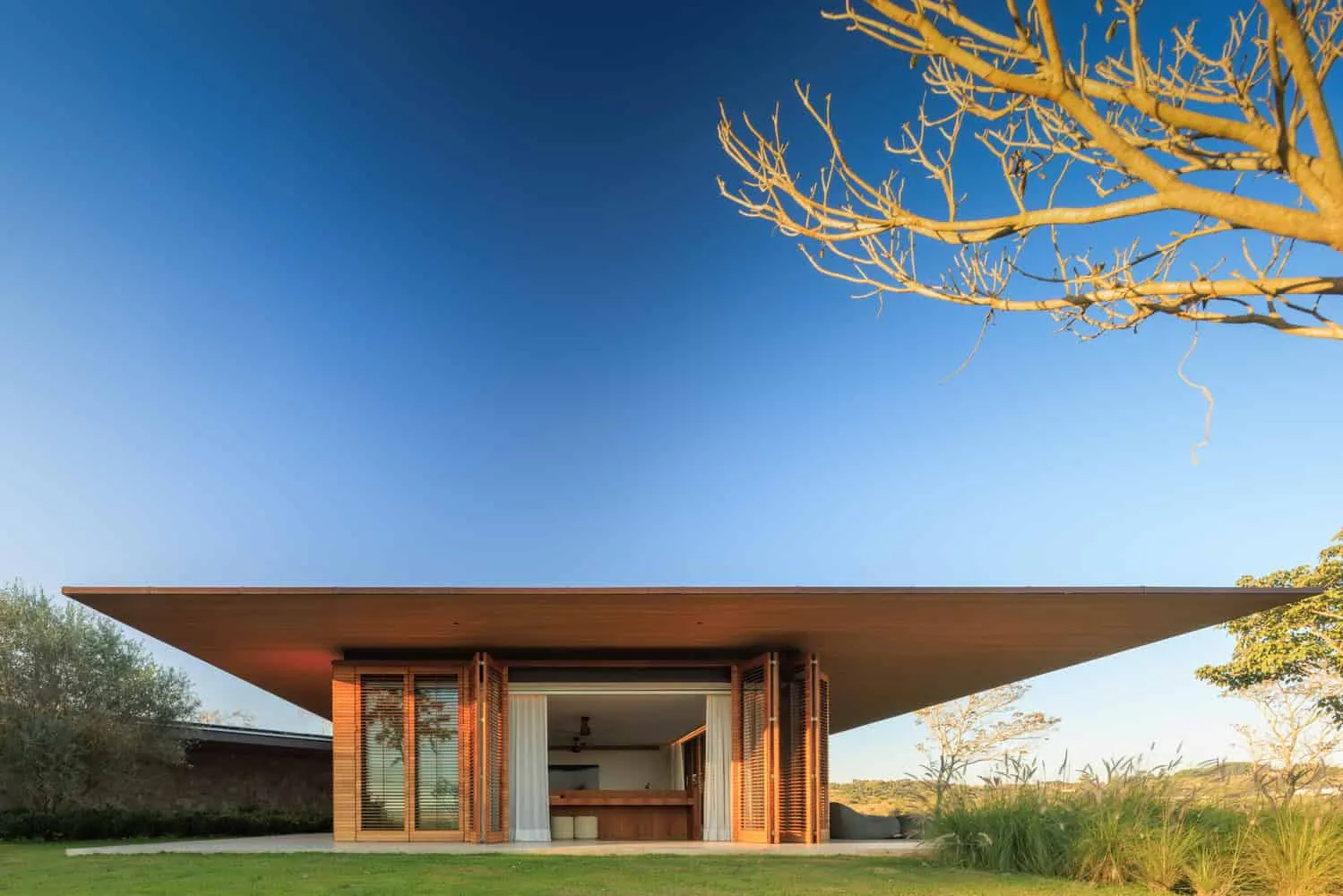 House TM – front with wide eave and wooden blinds, Brazil
