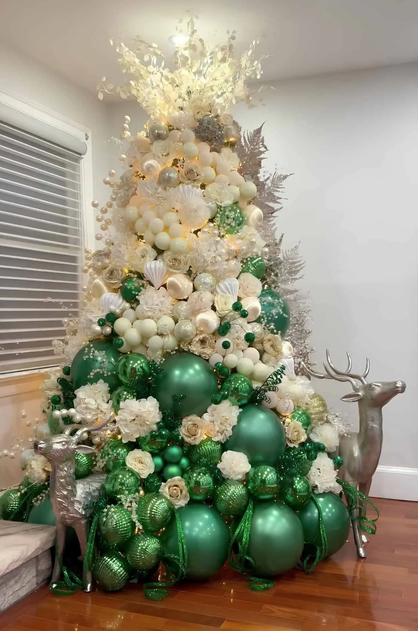 翡翠绿与奶油圣诞树，装饰着大饰品、白花和银驯鹿