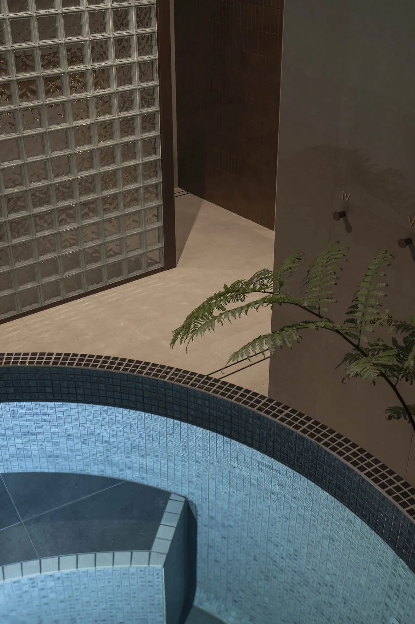 珀斯艾默湾浴室内蓝色冷水跳跃池，玻璃块与暖色调环绕